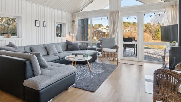 A modern living room with a sectional sofa, a round coffee table, and a wicker chair. - "Etel" - 600m from the sea by Interhome (Ebeltoft)