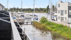 Un puerto deportivo con varias embarcaciones amarradas, un puente y un edificio con ventanas amplias.