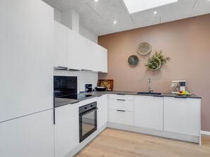 Kjøleskap, ovn, oppvaskmaskin og høy barnestol