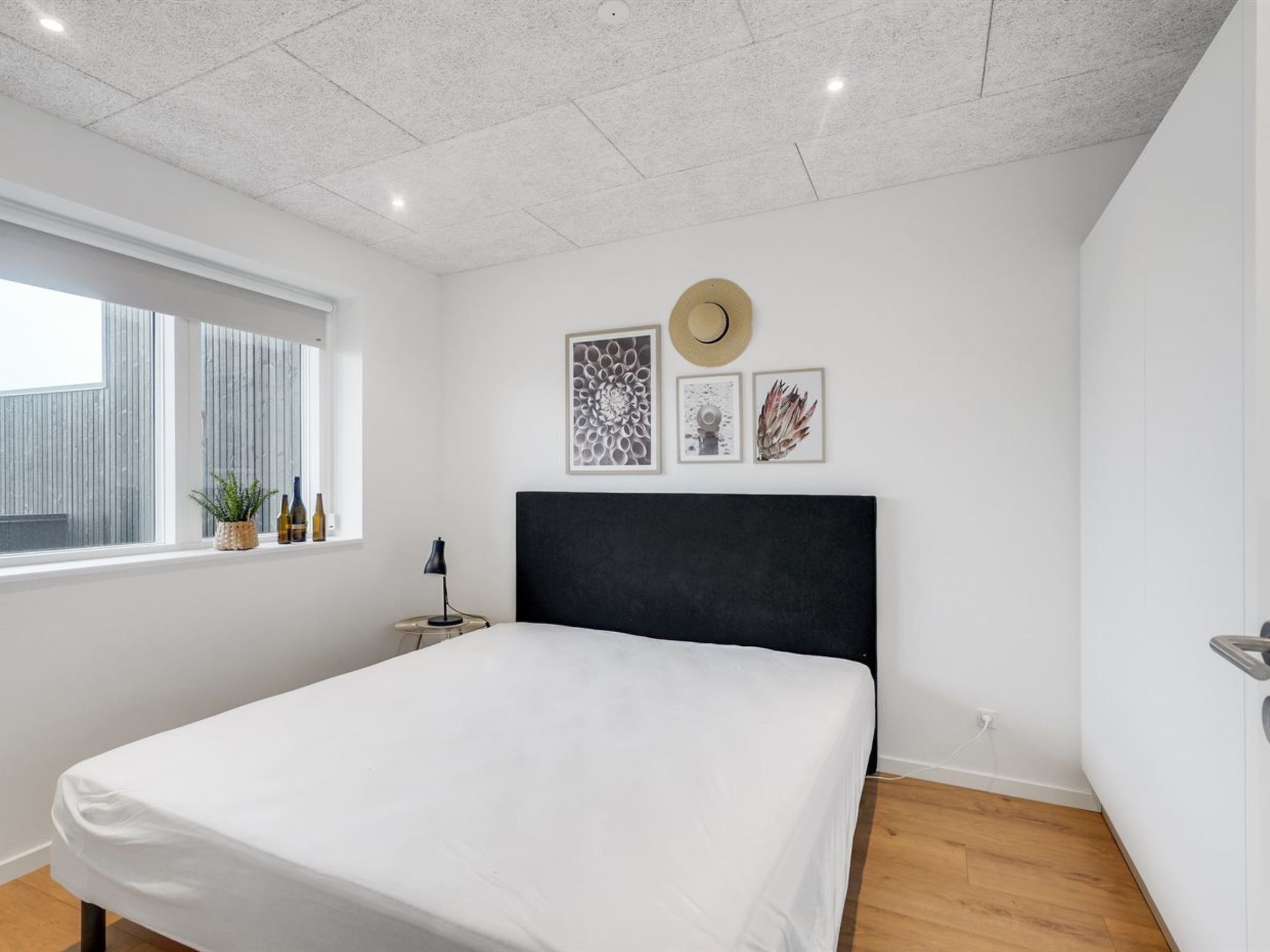 Une chambre moderne avec un grand lit, une fenêtre donnant sur un beau paysage et des œuvres d’art murales.