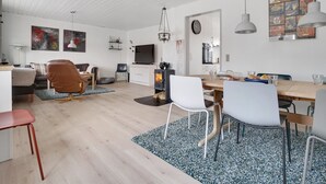 Un espacio moderno de estar con comedor, cocina y una zona de descanso acogedora.