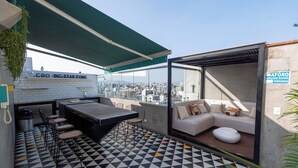 A rooftop terrace with a dining area, seating, and a view of the city. - 3BedRoom APT in the HEART of BARRANCO, LIMA, PERU 🇵🇪 (Barranco)