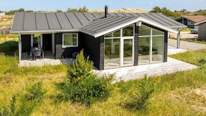 A modern house with a covered patio, large windows, and a sloped roof. - "Raakel" - 950m from the sea by Interhome (Thisted)