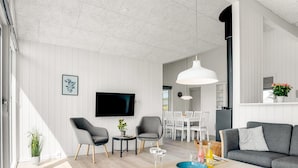 A modern living room with a flat-screen TV, two grey armchairs, a wooden coffee table, and a grey sofa. - "Raakel" - 950m from the sea by Interhome (Thisted)