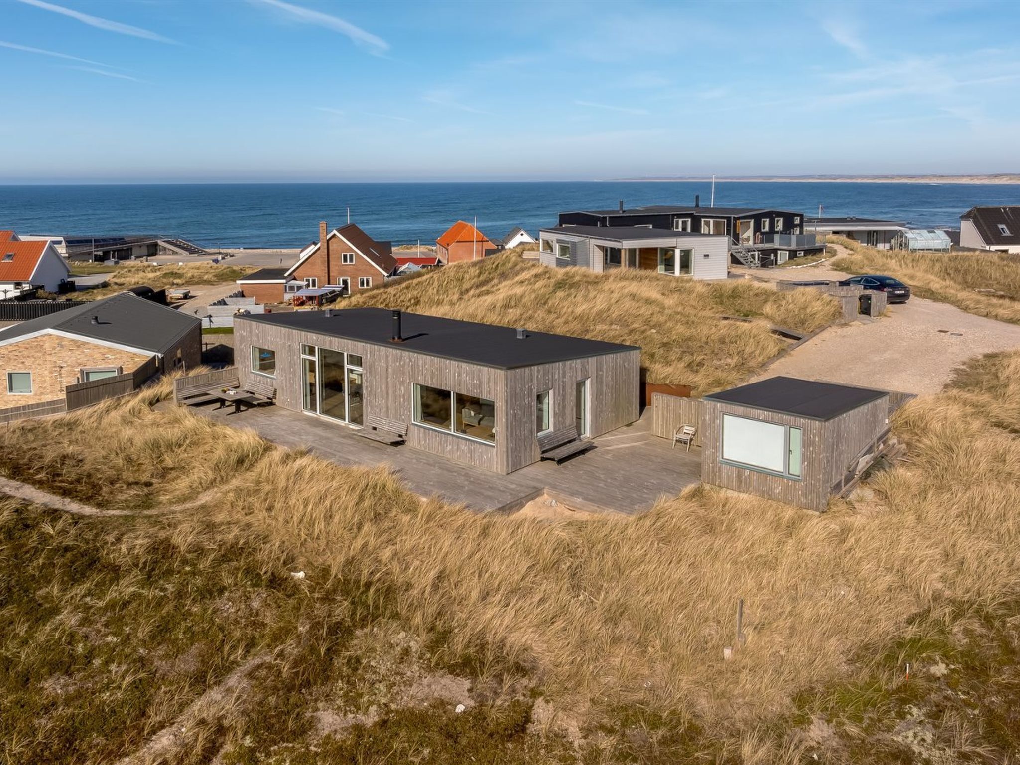 A coastal property with modern architecture, including a prominent building with large windows and a flat roof.
