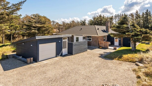 Een modern huis met een grindpad, een garage en een klein buitenruimte.