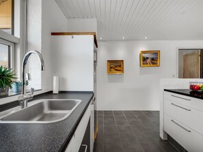 A modern kitchen with a stainless steel sink, a black countertop, and a white cabinet. - "Örjan" - 400m from the sea by Interhome (Thisted)