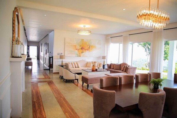A spacious living area with a large dining table, comfortable seating, and a chandelier. - Benito Bungalow by The Serendipity Collection (Haputhale)
