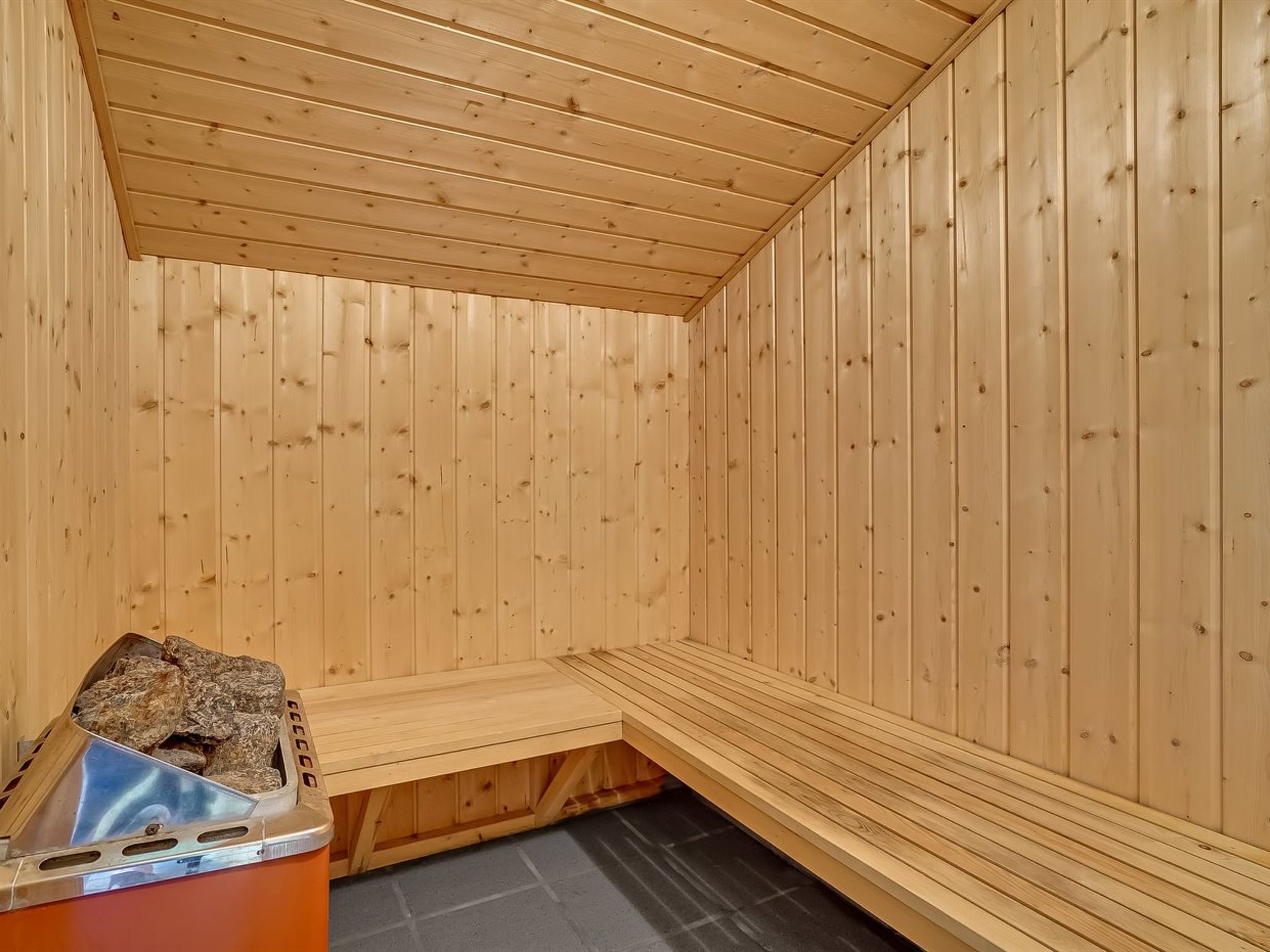 A sauna room with wooden walls and a bench.