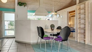 Une cuisine moderne avec un îlot central, des chaises noires et un luminaire suspendu.