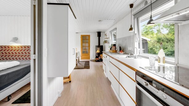 Une cuisine moderne dotée d’un îlot central, d’une cuisinière intégrée et d’une grande fenêtre offrant une vue sur l’extérieur.