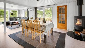 Un intérieur moderne comprenant un coin repas, un canapé et une cheminée.