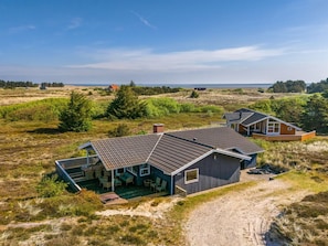 Une maison située sur la côte, dotée d’un patio couvert, d’une terrasse et offrant une vue sur la mer.
