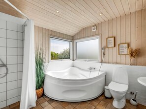 A modern bathroom with a freestanding bathtub, a toilet, and a sink.