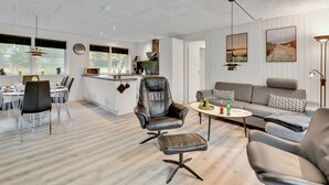 A modern living room with a sofa, chairs, a coffee table, and a dining area with a table and chairs. - "Øn" -  from the sea by Interhome (Hvide Sande)