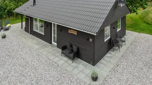 A modern black house with a tiled roof, a satellite dish, and a gravel driveway. - "Øn" -  from the sea by Interhome (Hvide Sande)