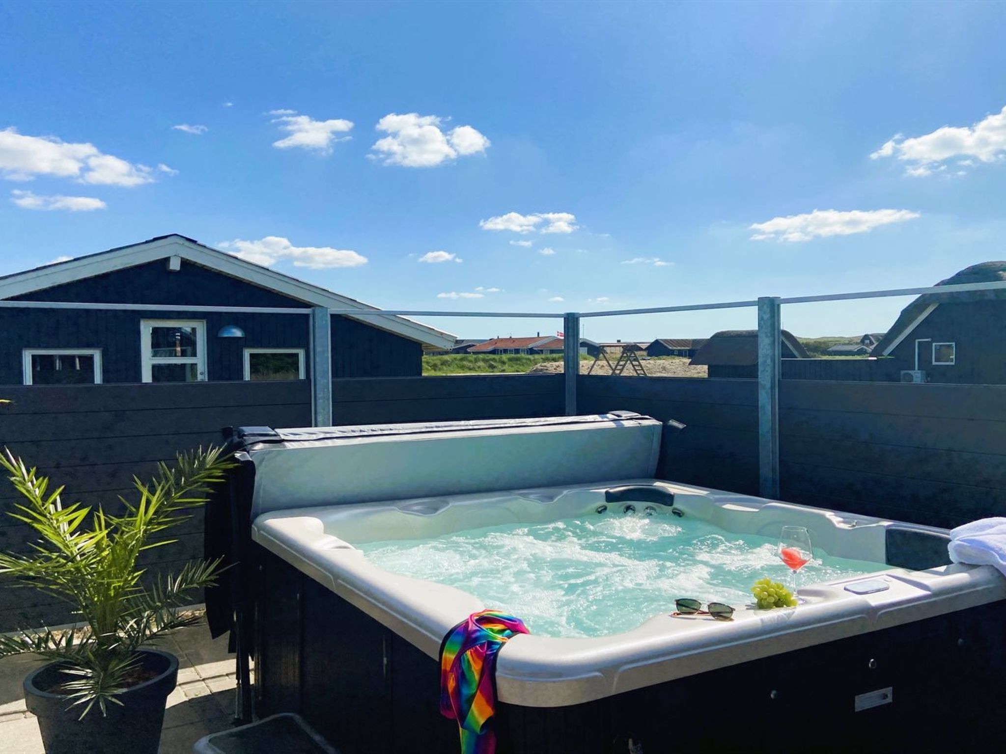 Jacuzzi con vista a una casa y paisaje.