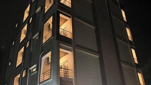 A multi-story building with balconies and illuminated windows at night. - Palladium Luxury Suites  (Hyderabad)