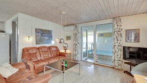 Un salon spacieux avec un canapé en cuir, une table basse et une cheminée.