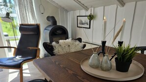 Une table de salle à manger en bois, avec une assiette blanche, trois vases en verre et une plante en pot.