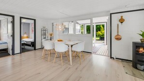 Ein modernes Interieur mit Essbereich, Kamin und Blick ins Freie.