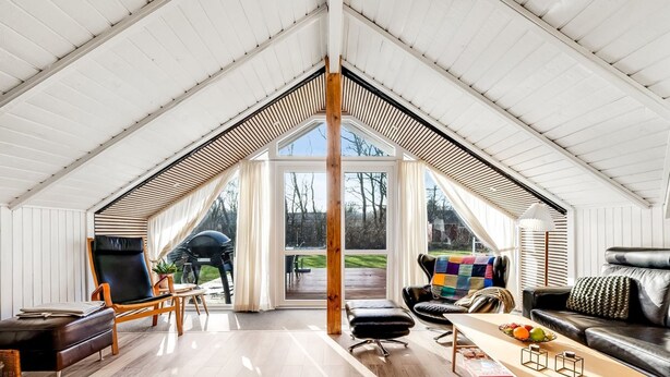 A spacious loft with a high ceiling, a wooden floor, a dining area with a table and chairs, a sofa, and a view of the outdoors. - "Anu" - 300m to the fjord by Interhome (Hemmet)