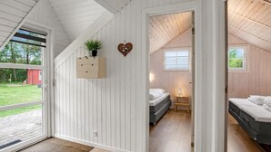 A bedroom with a bed, bedside table, and a window. - "Anu" - 300m to the fjord by Interhome (Hemmet)