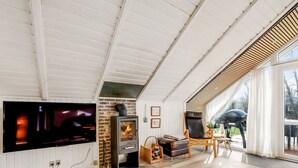A spacious living area with a fireplace, a television, and a view of the outdoors. - "Anu" - 300m to the fjord by Interhome (Hemmet)