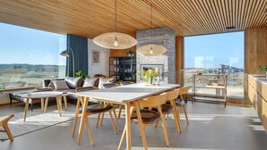 A spacious living area with a large wooden ceiling, a fireplace, and a dining table with chairs. - "Caterina" - 100m from the sea by Interhome (Blåvand)