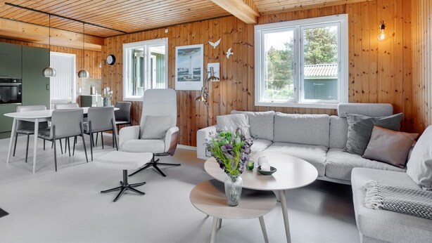 A modern interior with wooden walls, a dining area with chairs and a table, a sofa, and a coffee table with flowers. - "Absolon" - 1.5km from the sea by Interhome (Blåvand)