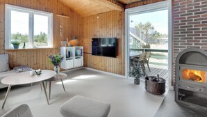 A cozy living room with wooden walls, a fireplace, a TV, and a dining area with a table and chairs. - "Absolon" - 1.5km from the sea by Interhome (Blåvand)