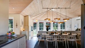 A modern kitchen with a dining area, wooden ceiling, and large windows. - "Ingmund" - 2km from the sea by Interhome (Blåvand)