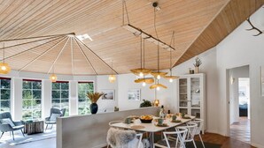 A spacious dining area with a high wooden ceiling, a central island with seating, and pendant lighting. - "Ingmund" - 2km from the sea by Interhome (Blåvand)