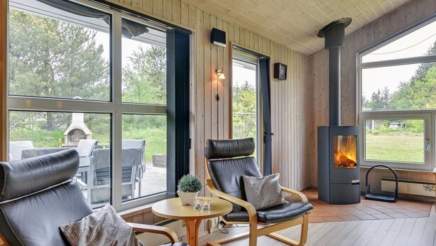 A cozy room with two leather chairs, a small table, and a wood-burning stove. - "Rudy" - 900m to the fjord by Interhome (Blåvand)