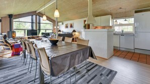 A spacious living area with a large dining table, comfortable seating, a fireplace, and a kitchen with modern appliances. - "Rudy" - 900m to the fjord by Interhome (Blåvand)