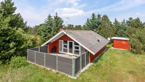 A single-story house with a sloped roof, a fenced patio area, and a satellite dish. - "Egbert" - 900m from the sea by Interhome (Vejers Strand)