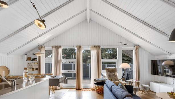 A spacious living area with a high ceiling, a sofa, a TV, and a dining area with a table and chairs. - "Egbert" - 900m from the sea by Interhome (Vejers Strand)