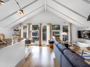 A spacious living area with a high ceiling, a sofa, a TV, and a dining area with a table and chairs. - "Egbert" - 900m from the sea by Interhome (Vejers Strand)