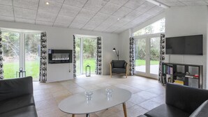A spacious living room with a large TV, a fireplace, and a comfortable seating area.