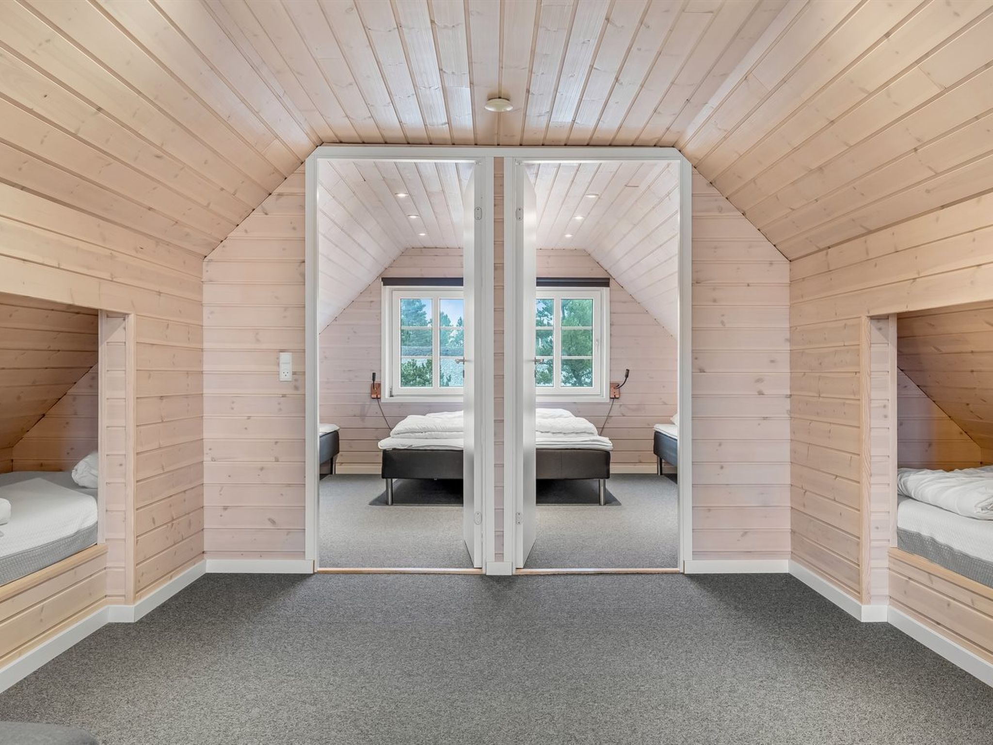 A bedroom with a mirrored closet door, a window, and a bed.