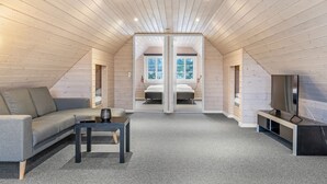A modern attic bedroom with a sloped ceiling, a sofa, a coffee table, a TV, and a large window. - "Madalena" - 2.8km from the sea by Interhome (Rømø)