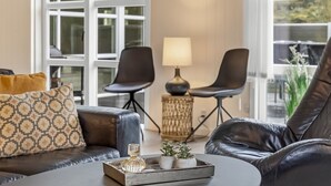 A modern living room with a leather sofa, two black chairs, a round coffee table, and a side table with a lamp. - "Madalena" - 2.8km from the sea by Interhome (Rømø)