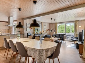 A modern kitchen with a central island, dining area with a round table, and a cozy seating area with a sofa and chairs. - "Gabriela" - 1km from the sea by Interhome (Rømø)