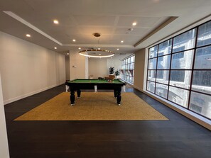 Relax by the pool table in a spacious room with a city view.