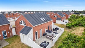 A residential area with multiple brick houses, each featuring a sloped roof and a small patio with outdoor furniture. - "Withulf" - 2.3km from the sea by Interhome (Rømø)