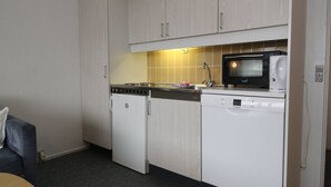 A compact kitchen with a microwave, dishwasher, and stove. - "Britt" - 100m from the sea by Interhome (Fanø)