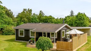 A two-story house with a deck, a covered outdoor seating area, and a fenced yard. - "Silvana" - 750m from the sea by Interhome (Væggerløse)