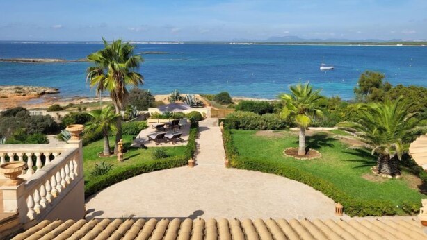 A coastal property with a view of the sea, a patio with outdoor furniture, and a well-maintained garden. - Las Gaviotas Style & Charm by Interhome (Ses Salines)