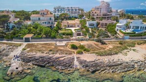 An aerial view of a coastal residential area with houses, clear waters, and rocky terrain. - Las Gaviotas Style & Charm by Interhome (Ses Salines)