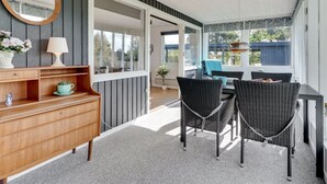 A covered patio area with a wooden bench, wicker chairs, a small table, and a wall-mounted mirror. - "Ilene" - 1km from the sea by Interhome (Bogø By)